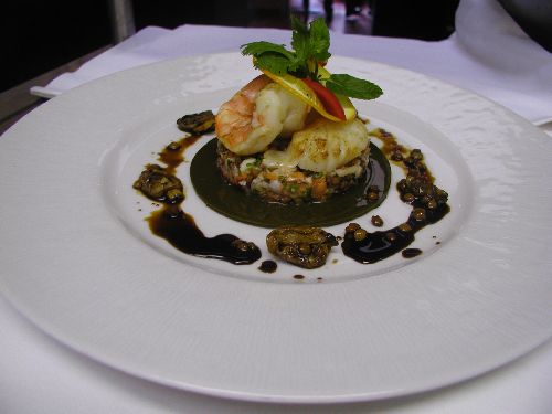 Sur une feuille d'épinard, salade de fruits de mer aux lentille, vinaigrette de palourdes à l'orange