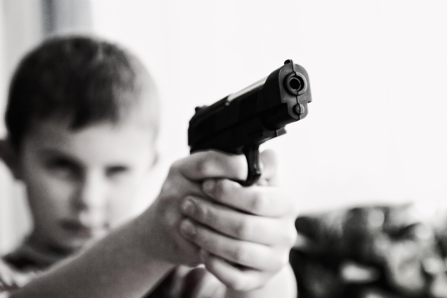 enfant tenant une arme à feu indiquer