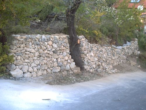 Mur en pierres de récupérations en cours