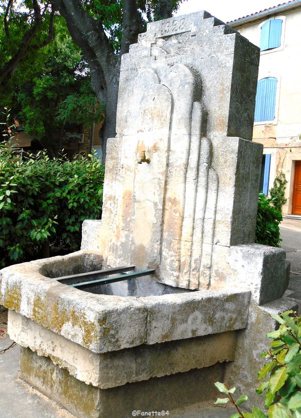 Fontaine sur la place de l'église datée de 1928 à Goult