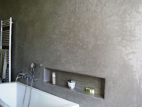 Mur de salle bain avec niche en tadelakt gris foncé.
