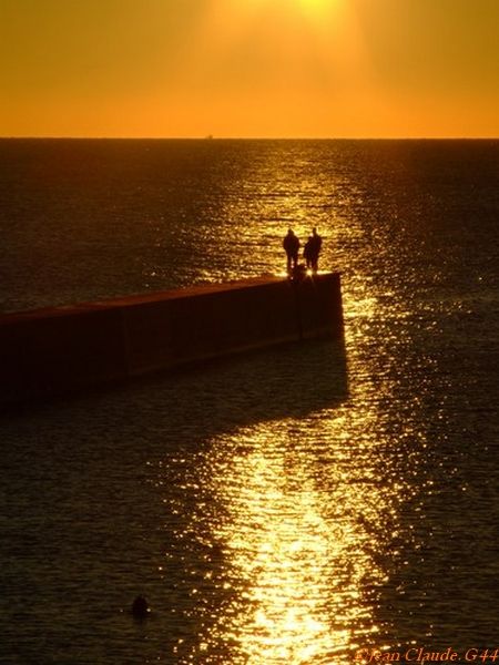 Paillettes dorées sur l'onde salée sous un ciel orangé à Batz-sur-mer