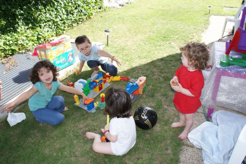 Les enfants sont tranquillement installés dans le jardin, en attendant la piscine