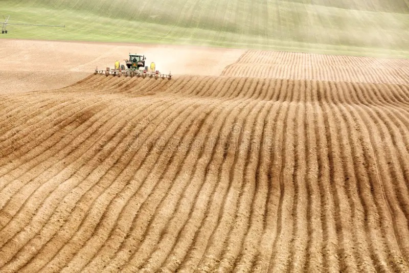 john-deer-tractor-pulling-plowing-implement-plows-field-rexburg-idaho-usa-may-farm-aerates-soil-preparation-170874685.jpg