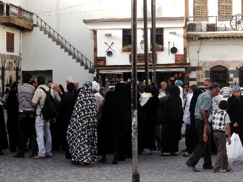 Femmes en noir et touristes devant la mosquée des Omeyades.