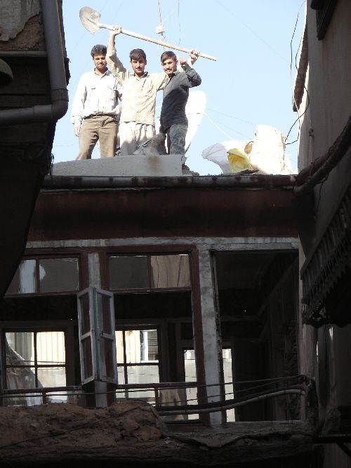 Vue de la rue. Les ouvriers sur le toit.