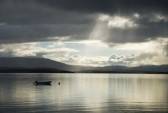 8719475-quiet-water-is-shining-under-the-sunbeams-struggled-through-white-clouds-norwegian-fjord-is-photogra.jpg