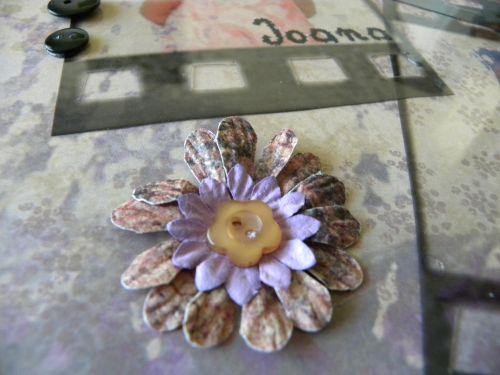 Composition de pétales de fleurs maintenue avec un bouton fleur