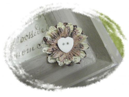 Composition de pétales de fleurs maintenue avec un bouton coeur blanc