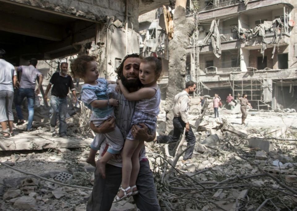 809049-un-syrien-transporte-ses-deux-petites-filles-au-milieu-des-ruines-apres-une-attaque-au-baril-de-dyna.jpg