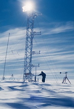 12 - 13 - Base Charcot 1957 un des 3 hivernants inspecte équipements de mesures installés sur la tour de micrométéorologie qui éclipse le soleil.jpg