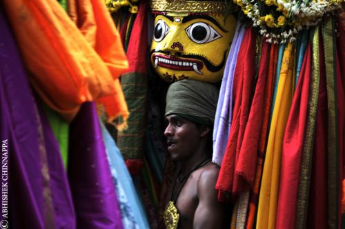 A chomana kumitha or a mask dancer rests after a street performance - Mysore