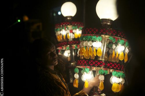 A young boy carries ornemental lights to welcome the bride groom during a wedding - Rishikesh