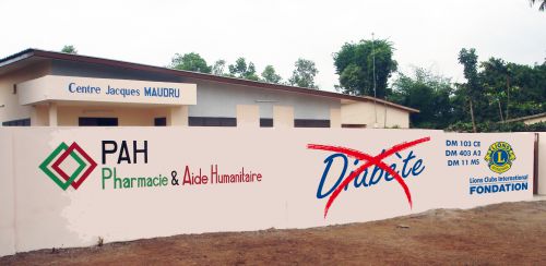 Mur de façade de la maison du diabète à Sakété avec les logos Pharmacie Humanitaire, Fondation Internationale Lions etc.