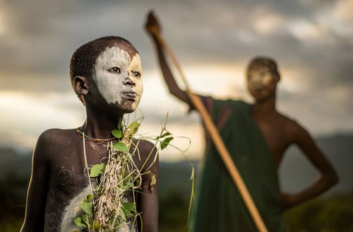 Un garçon de la tribu nomade suri en Éthiopie, avec la tenue traditionnelle et le visage et le corps peints