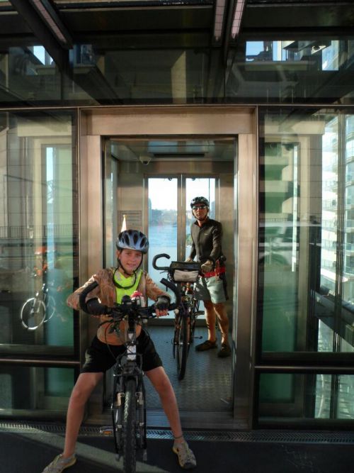 En fait tout est prevu ici pour le vélo.  Du port tu prends l'ascenseur pieton vélo  pour rejoindre la piste cyclable dédiée  pour traverser le  pont