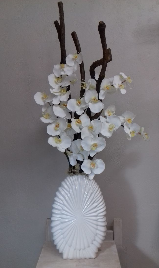Orchidées blanches et bois dans grand vase blanc. Hauteur 105cm.