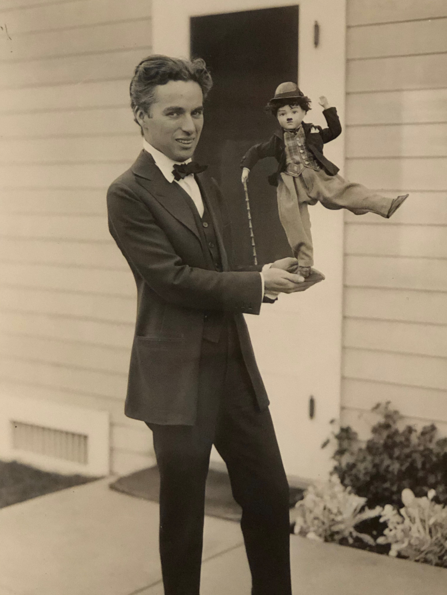 Chaplin posant avec une poupée à l'effigie de Charlot vers 1920