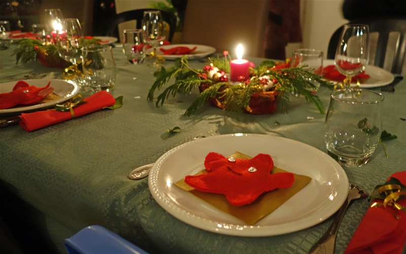 La table du réveillon, nappe verte, décor rouge et or. Pour les cadeaux d'assiette, j'ai mis quelques chocolats dans des étoiles de mer en feutrine rouge.