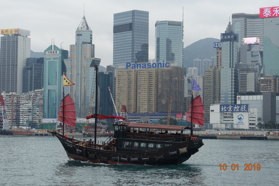 Une jonque traditionnelle aménagée pour le tourisme et en fond d'image LA banque, très visible à Hong Kong