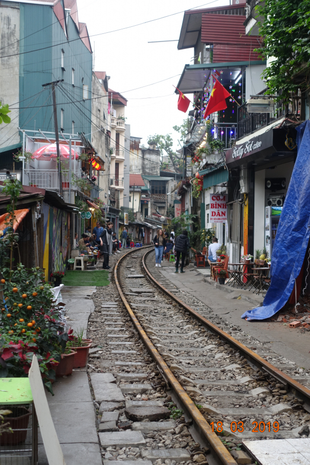 
Le train - un VRAI train, pas un petit train pour touristes - traverse Hanoi et longe les ruelles où la vie s'organise en fonction des horaires approximatifs de passage du train. Un vrai business s'est organisé pour le tourisme : des bars, des marchands ambulants etc...Quand le train passe, très lentement parait-il (car nous ne l'avons pas vu), plusieurs fois par jour, tout le monde range ses affaires et les remet en place ensuite.