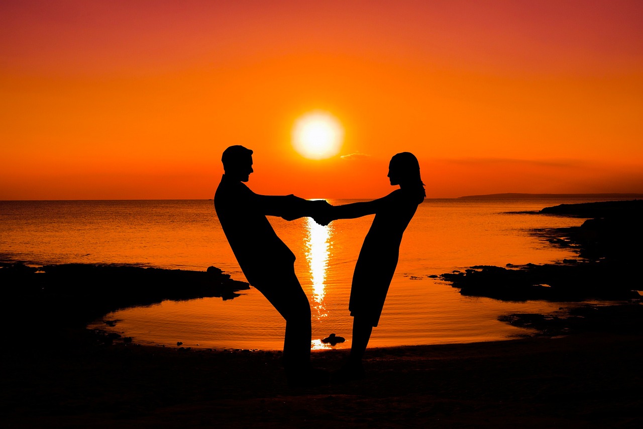 Un couple se tenant les mains à la plage 