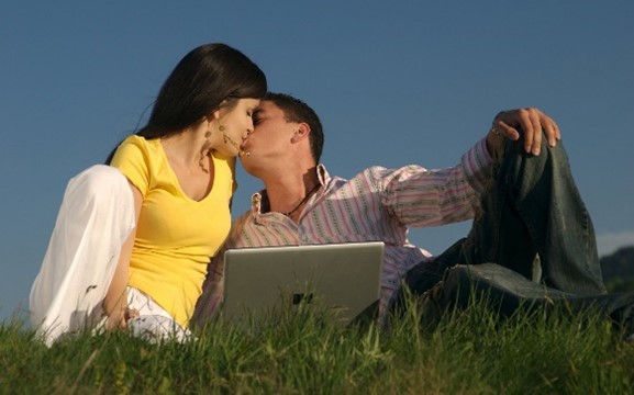 Des amoureux qui s’embrassent dans l'herbe