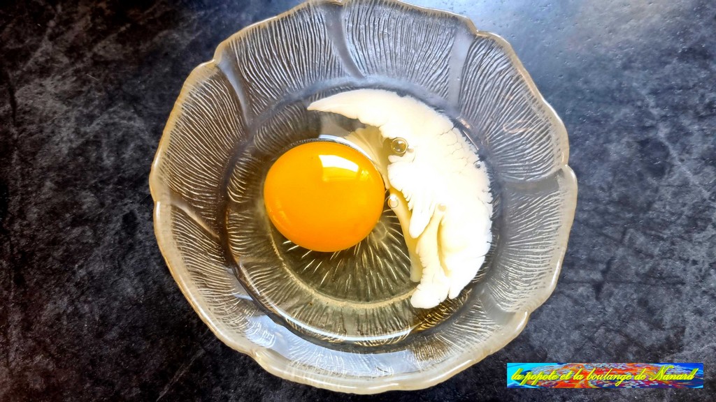 Casser un œuf dans un ravier avec une cuillère à soupe de lait