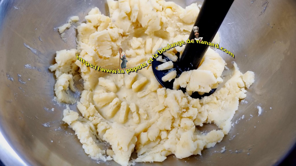 Écraser les pommes de terre avec le beurre dans un cul de poule à l\\\'aide d\\\'un presse purée