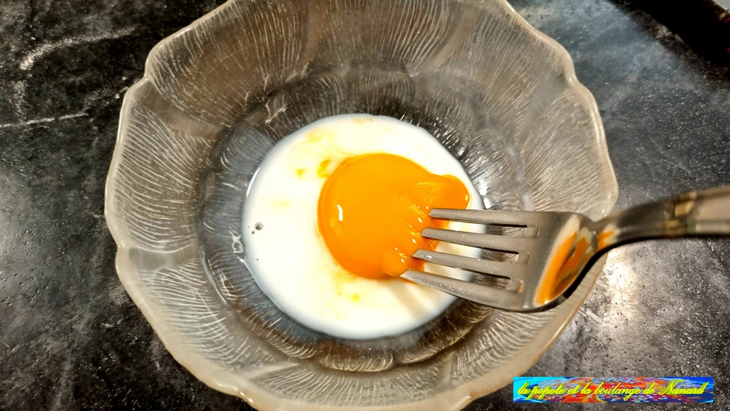 Mélanger le jaune d\\\'œuf avec la cuillère à soupe de lait dans un ravier