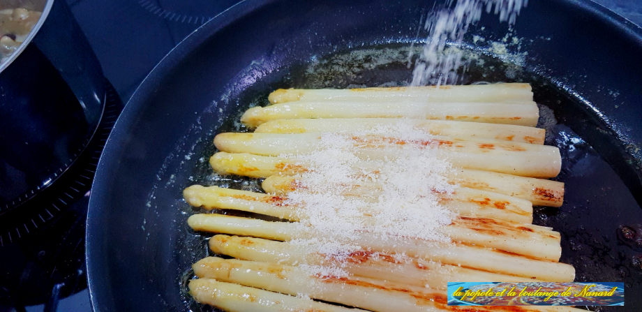 Saupoudrer de parmesan puis remuer les asperges en secouant la poêle pour bien les enrober