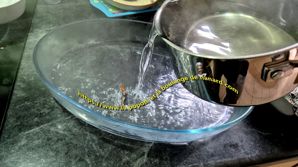 Verser de l\\\'eau bouillante dans un garnd plat à four