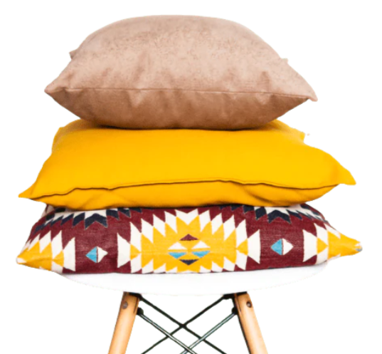 Des coussins de divers designs posés sur un tabouret