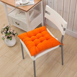 Une chaise avec un coussin orange 